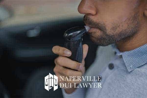 a photo of a man blowing into a breathalyzer